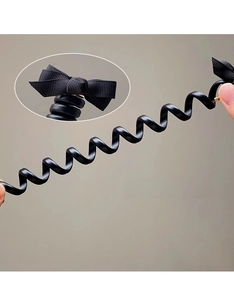 Élastique à cheveux spirale noir avec nœud, étiré pour montrer sa grande flexibilité