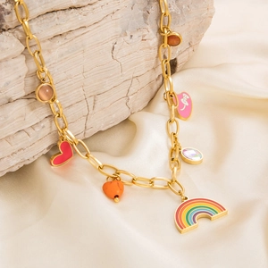 Detail of gold chain necklace with colorful rainbow, heart pendants and clear gemstones