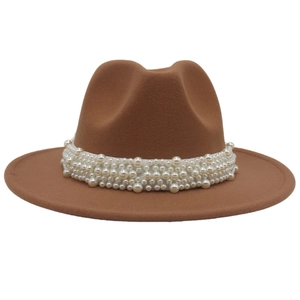 Detailed view of white pearls on the band of a brown wide-brim felt fedora hat
