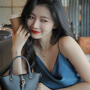 Minimalist gold heart pendant necklace for women shown on a model in a lifestyle setting