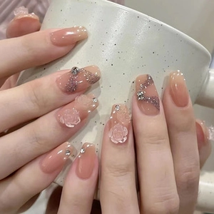 Detailed view of handmade press-on nails with 3D white rose and glitter wave patterns