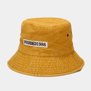 Detail of mustard yellow washed canvas bucket hat with FOUNDED 1986 embroidery