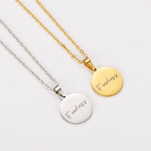 Collana minimalista con pendente rotondo inciso Fearless in finiture oro e argento