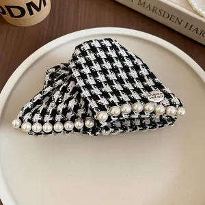 Houndstooth hair claw with faux pearls and metal charm in a ceramic tray setting