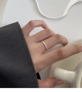 Dettaglio di un anello d'argento minimalista con una finitura martellata irregolare