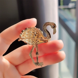 Detailed back view of gold plated flamingo brooch showing pin clasp and metal texture