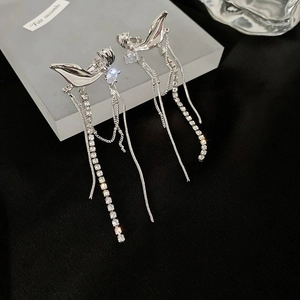 Macro shot of silver zircon butterfly tassel earrings with long dangling rhinestone chains