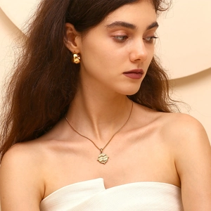 Dettaglio della collana con ciondolo tarocchi placcata oro 18K e orecchini a C
