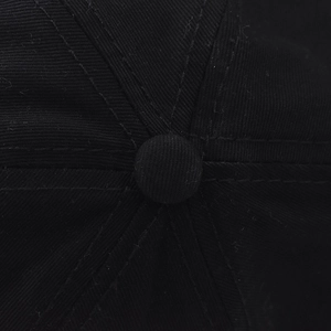 Close-up of black cotton twill baseball cap crown with button and stitched panels