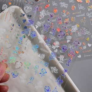 Detailed macro shot of Valentine's Day nail stickers with rose and laser heart patterns
