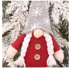 Close-up of a Christmas gnome plush with grey knitted hat and white braided pigtails