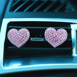 Pink rhinestone heart car air vent clips showing installation on air conditioner vents
