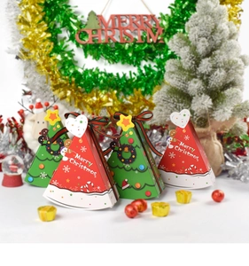 Close-up of red and green Christmas tree triangle gift boxes with festive ribbons