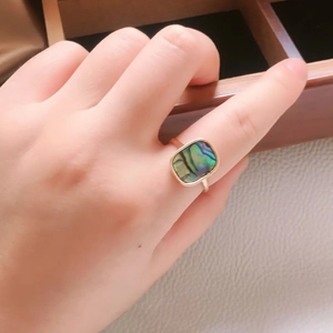 Golden ring for women featuring a rectangular natural abalone shell stone on the finger