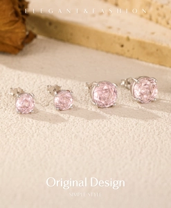 Detailed macro view of two sizes of pink zircon earrings in four-claw silver settings
