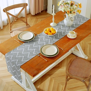 Detail of grey and white ripple pattern fabric table runner on a dining table