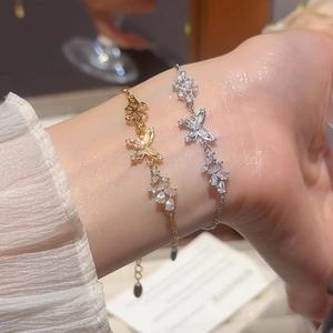 Detail of 18k gold plated butterfly bracelet with sparkling zircon stones on female wrist