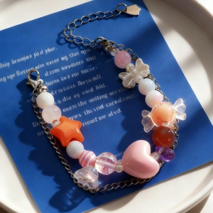 Vista macro de pulsera de cuentas coloridas con dijes de corazón sobre fondo azul