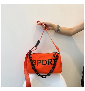 Détail du sac bandoulière en nylon orange avec chaîne noire et inscription sport