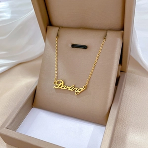 Macro shot of gold-plated Darling letter pendant necklace in a luxury jewelry gift box