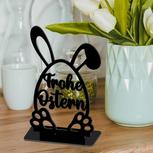 Detail of black Easter bunny ornament with Frohe Ostern cut-out on a wooden table