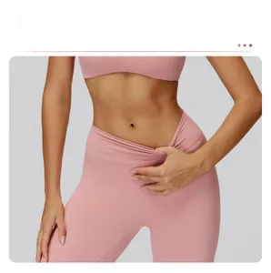 Détail d'un pantalon de yoga rose à taille haute montrant le contrôle du ventre et l'élasticité