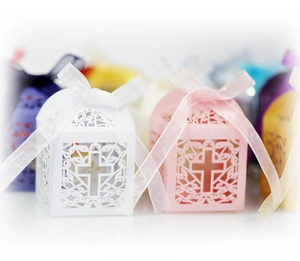 Detailed close-up of laser-cut cross hollow favor boxes with elegant ribbon bows