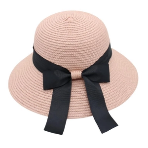 Detail of pink straw sun hat featuring a wide black grosgrain ribbon bow decoration