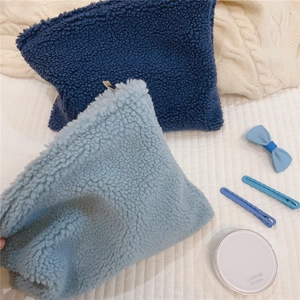 Detail of soft teddy fleece makeup pouches in blue colors with smooth white zippers