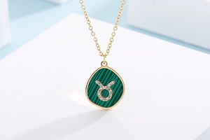 Macro shot of Taurus zodiac necklace with malachite pattern and diamond-set gold pendant
