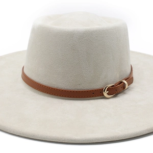 Close-up of beige wide brim felt fedora hat with brown leather band and gold buckle