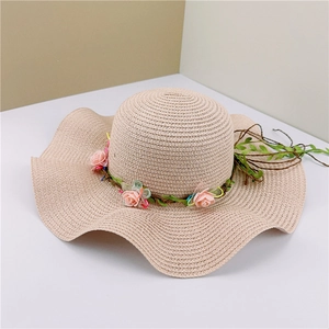 Beige woven straw sun hat with wide wavy brim and light pink rose flower accents