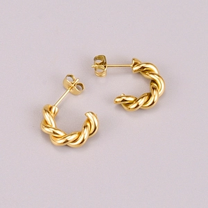 Detail view of gold-plated twisted rope C-shaped hoop earrings with butterfly backs