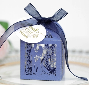 Detail of purple paper wedding favor box with navy blue ribbon and gold Thank You tag