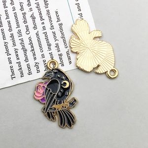 Macro detail of gothic raven pendant with black enamel wings and golden moon accents