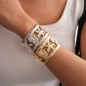 Detailed view of hollow open wide cuff bracelets with starfish and seashell patterns