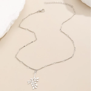 Elegant silver leaf pendant necklace with minimalist branch design on natural background