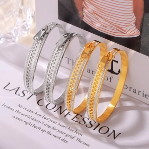 Creative 18k gold and silver zipper-style crystal bracelets on luxury magazine background