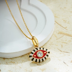 Detail of red and black enamel evil eye pendant necklace with clear zircon stone