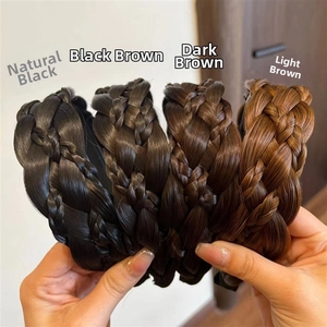 Close-up of hand holding braided hair headbands in four shades from black to light brown