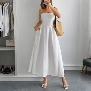 Elegant white strapless A-line maxi dress for women in a bright minimalist setting