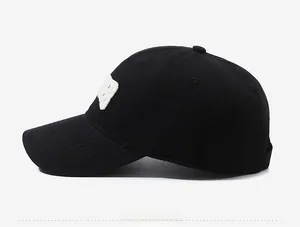 Detail view of the black cotton baseball cap side profile with white patch embroidery