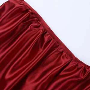 Gros plan d'une robe de soirée en satin rouge avec d'élégants détails froncés