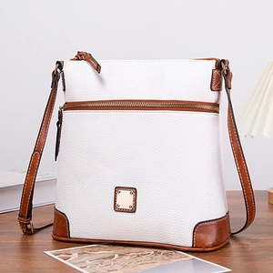 Macro detail of white and brown pebble leather texture on a crossbody bag with a logo plate