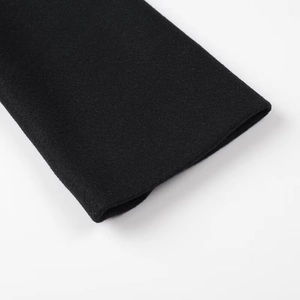Close-up of black wool blend fabric texture and stitching detail on jacket cuff