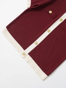 Detail of burgundy knit cardigan featuring cream contrast trim and gold lion buttons