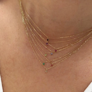 Detail of multi-layered 18K gold necklace with colorful zircon gemstones on neck