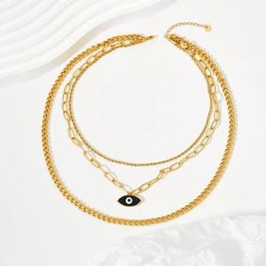 Three-layer gold evil eye necklace set with curb and paperclip chains on white background
