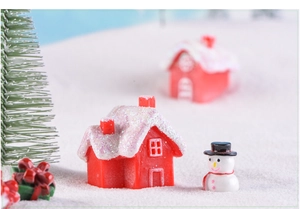 Macro view of a red glitter house with a miniature snowman and Christmas tree decor