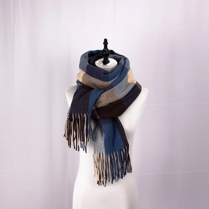 Detailed close-up of blue and brown plaid scarf featuring long decorative tassels
